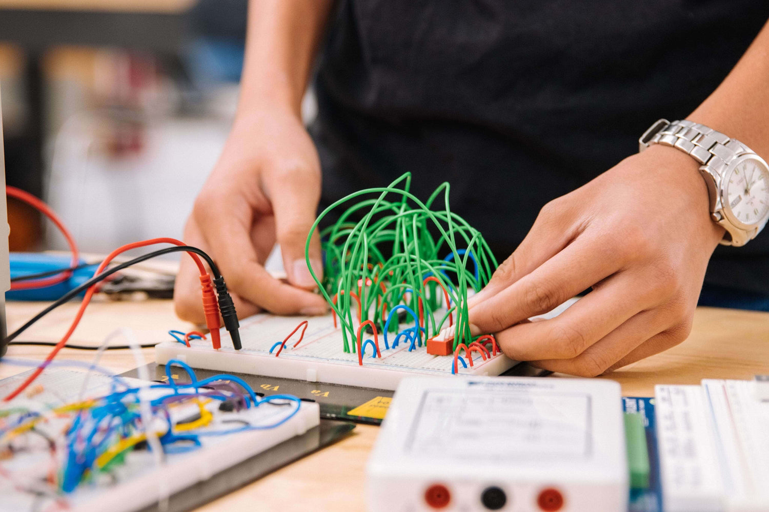 Person working with electronic components and wiring on a table