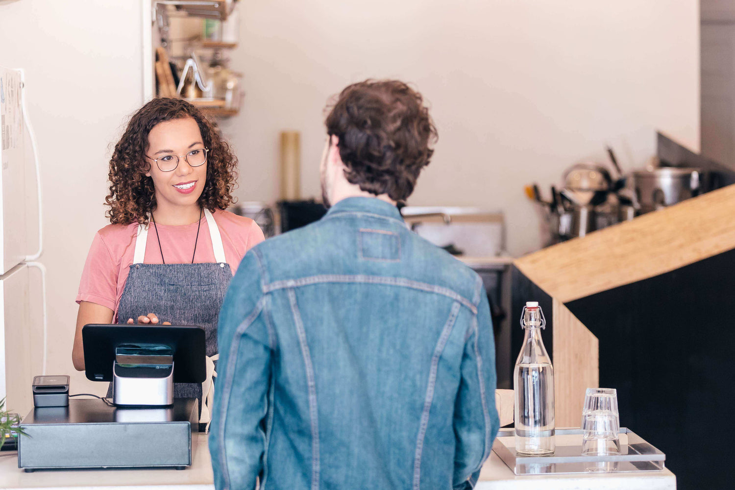 Customer interacting with a cashier at a counter in a store.