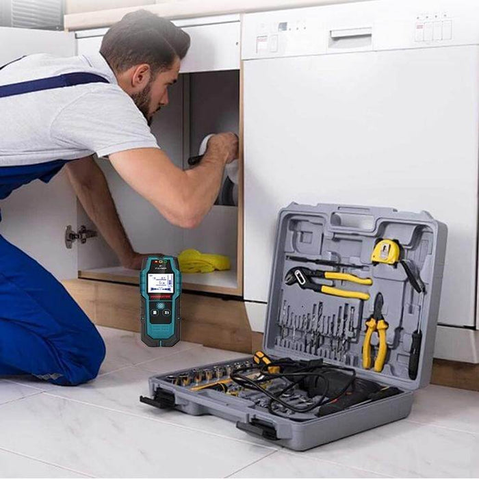 Technician using electronic inspection tool next to open toolbox with drill bits and pliers