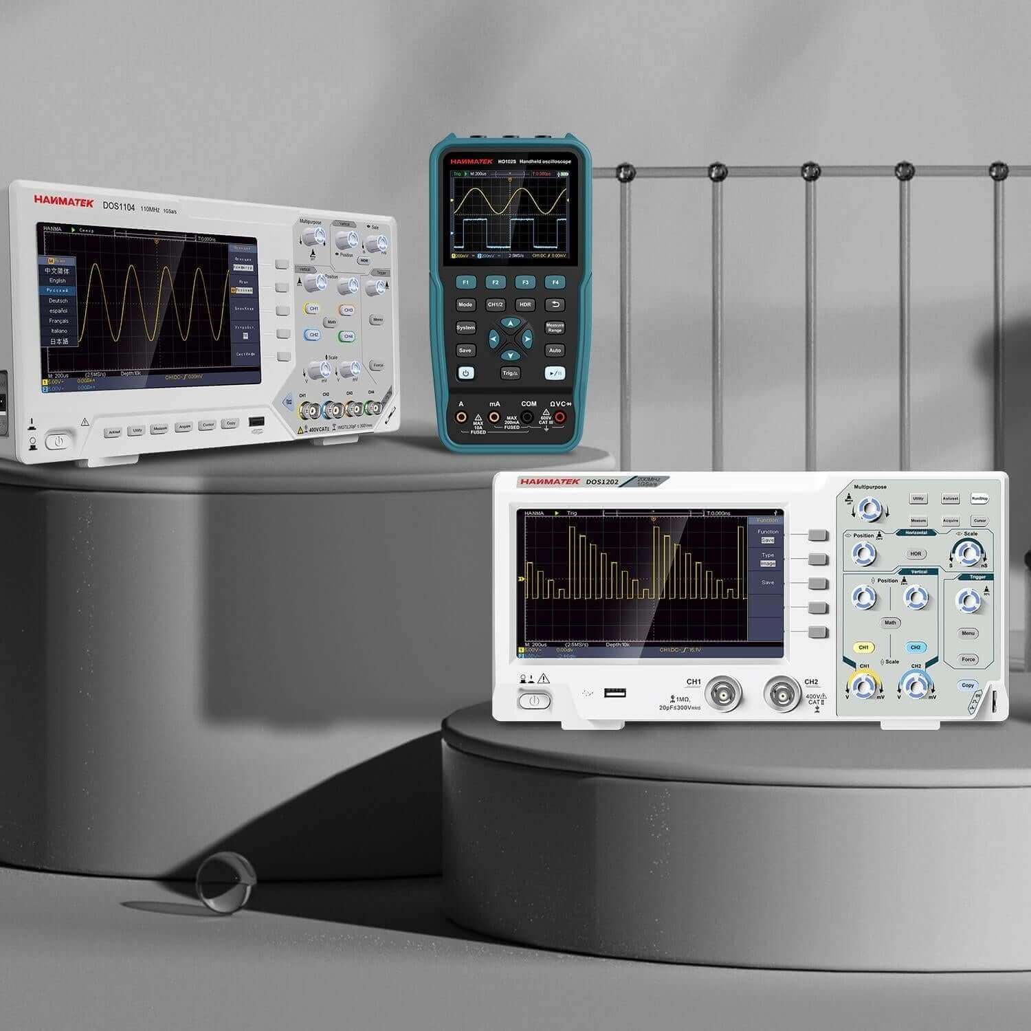 Digital oscilloscopes and handheld multimeter with waveform displays on a gray platform.