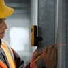 Professional using surveying and mapping tools for accurate measurements with a laser level and pencil