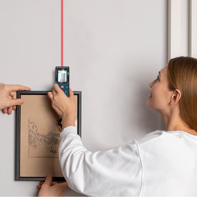 Professional using surveying and mapping tools for accurate measurements with a laser level and pencil
