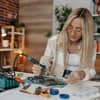 Woman using welding equipment for professionals at a workbench with tools and circuit boards