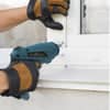 Hands using a cordless electric drill screwdriver to install a window frame with precision and ease