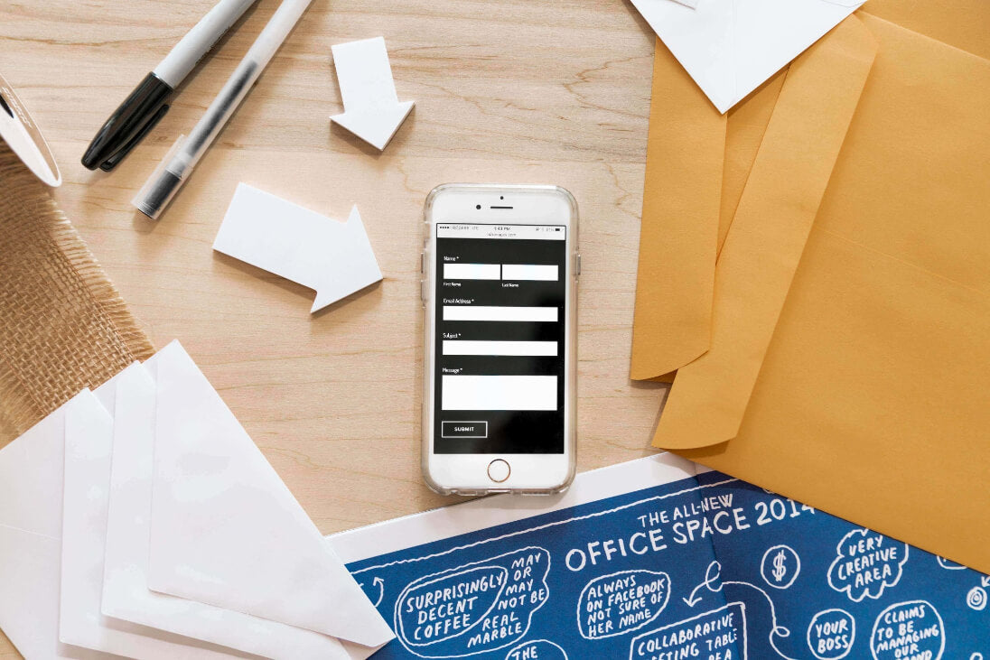 Tablet displaying a login screen on a desk with a plant, phone, and coffee cup.