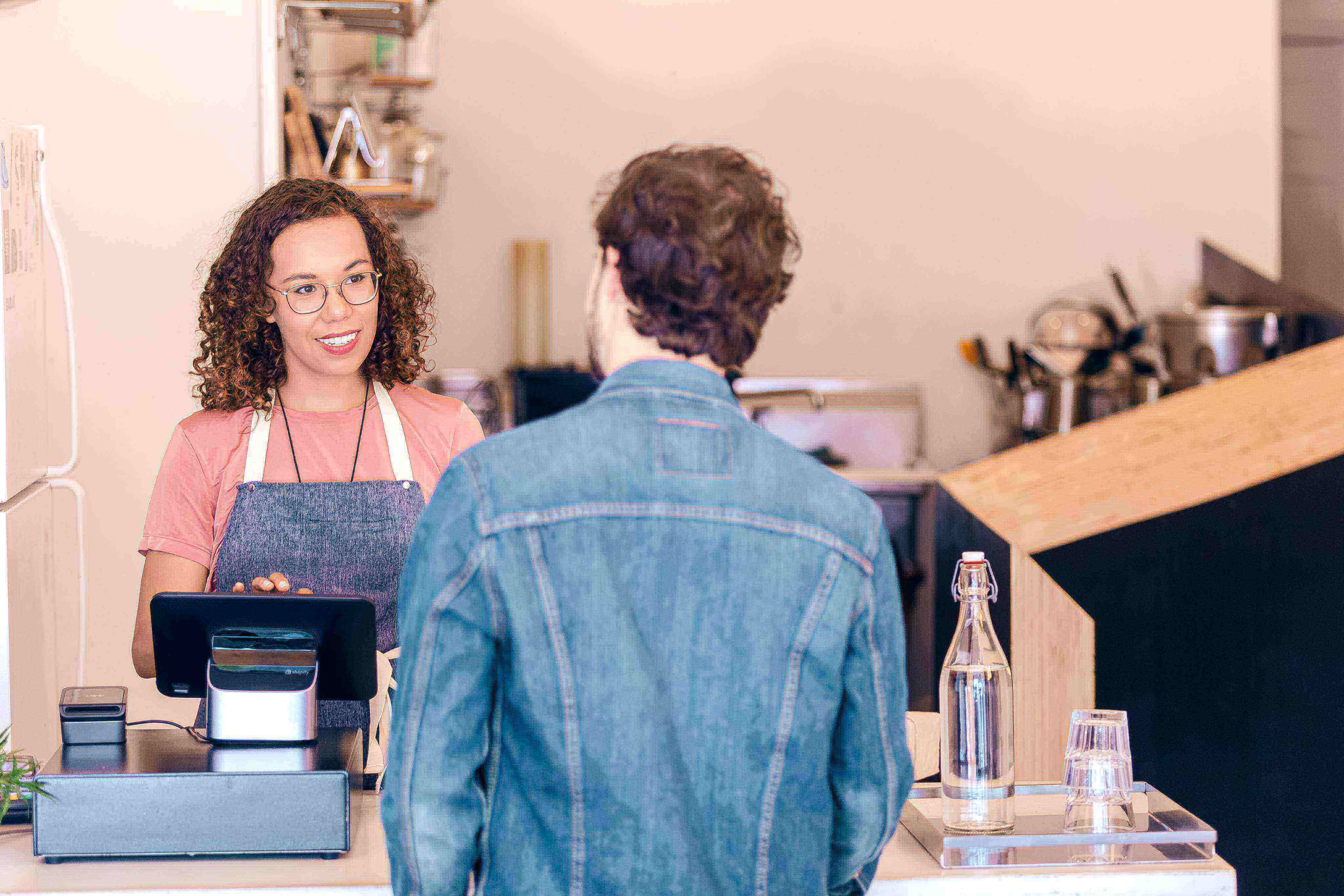 Customer interacting with a cashier at a counter in a store.